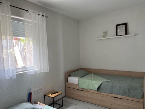 a small bedroom with a bed and a window at Vila V & S in Star Dojran