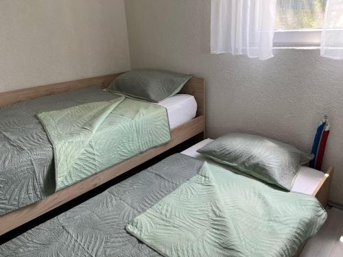 two twin beds in a room with a window at Vila V & S in Star Dojran