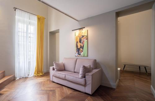 a living room with a couch and a painting at Palazzo Del Carretto-Art Apartments and Guesthouse in Turin
