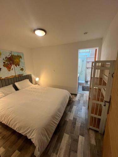 a bedroom with a large white bed and a ladder at Gîte à la ferme avec piscine in Urgosse