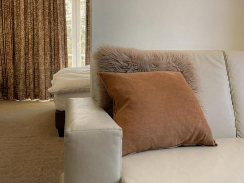 a couch with a pillow on it in a living room at Boutique Hotel Art de Vivre & SPA in Crans-Montana