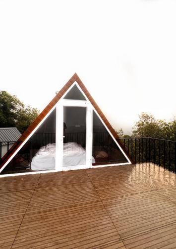 a bed in a tent on a deck at Maravillosso Sathram in Vandiperiyār