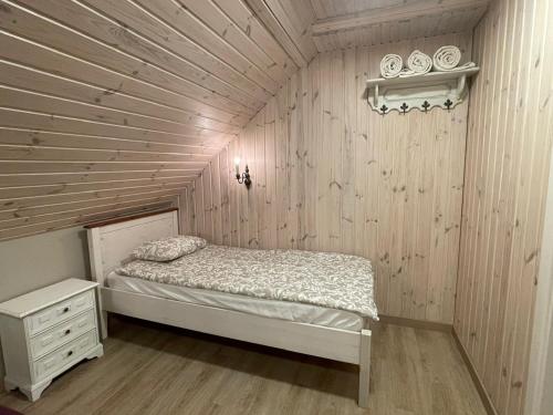 a small bedroom with a bed and a wooden wall at River Mind Villa with SPA in Zalioji