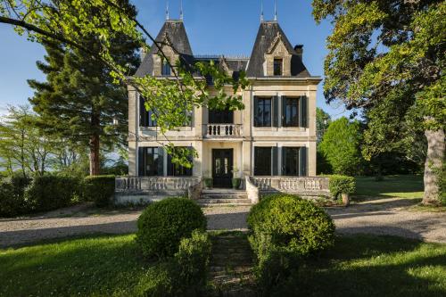 une vieille maison avec un portail devant elle dans l'établissement Château Lacoste Pujols near Saint Emilion, à Pujols Gironde