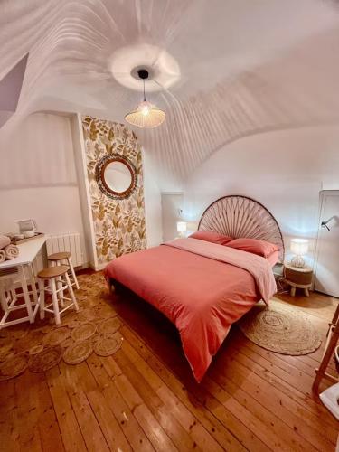 - une chambre avec un grand lit rouge et une table dans l'établissement Jolie maison, idéalement située, à Crozon