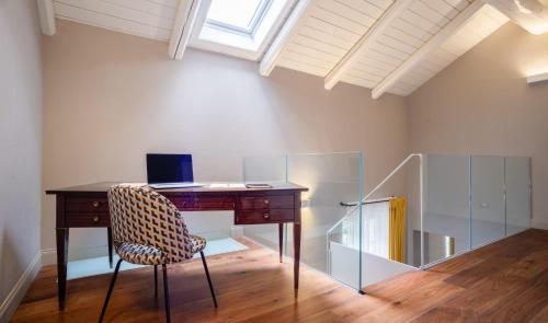 a desk with a chair in a room with a window at Palazzo Del Carretto-Art Apartments and Guesthouse in Turin