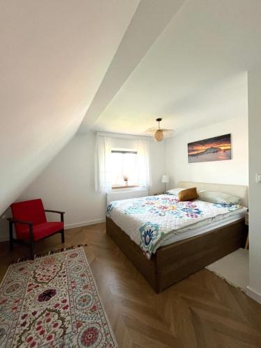 a bedroom with a bed and a red chair at Pod 20 in Jelenia Góra