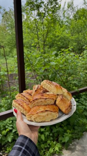 a person holding a plate of bread on a window at My home in Dilijan