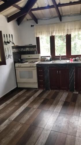a kitchen with a white stove and a sink at The Cozy Cabin in Bonao