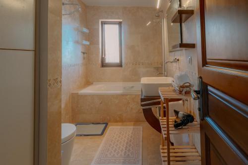 a bathroom with a tub and a sink and a toilet at Villa Mandalina, Cukurbag Peninsula-Kas in Kaş