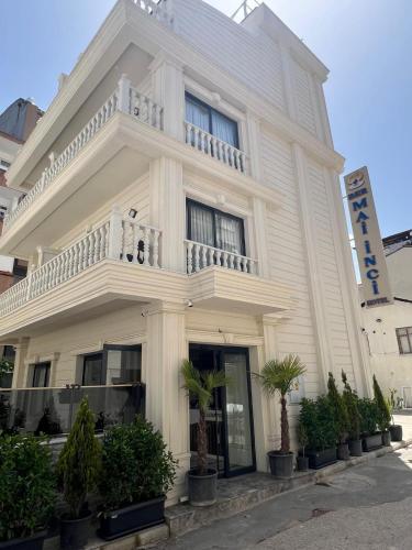a white building with a balcony on top of it at Ber Mai İnci Hotel Antalya in Antalya