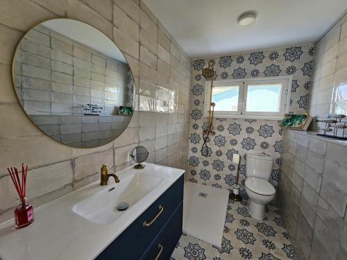 a bathroom with a sink and a toilet and a mirror at Casa Peñascales -Laxe- Costa da Morte in Laxe
