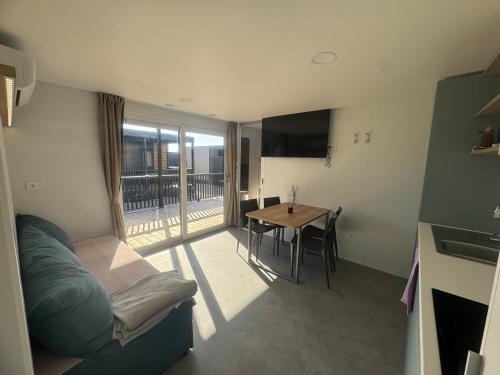 een woonkamer met een bank en een tafel met een balkon bij Mobile Enelia sun house in Sveti Petar