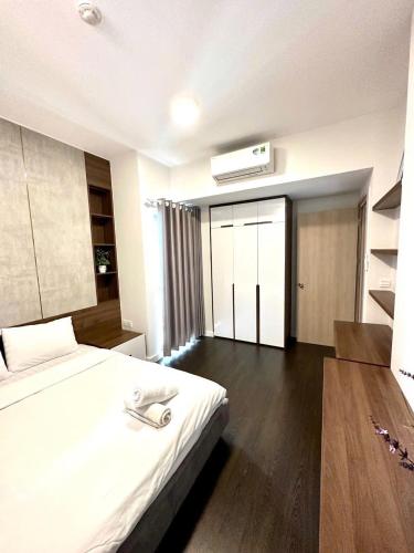 a bedroom with a large white bed and a window at Mina Homie in Ho Chi Minh City