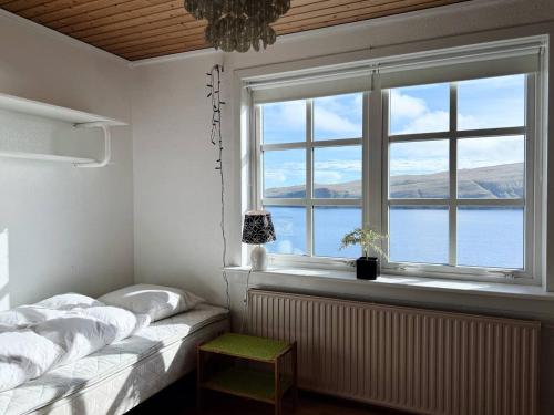 a bedroom with a bed and a large window at Panoramic Holiday Home With 5 Bedrooms And Fjord in Vágur