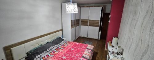 ein Schlafzimmer mit einem Bett mit einer rosa Decke in der Unterkunft Apartment Nio in Strumica