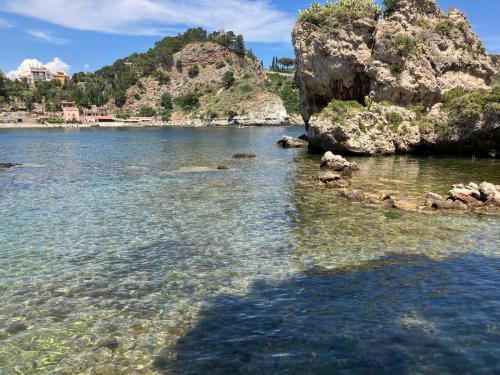a large body of water with a rocky shore at Taormina Roby Casa Vacanze in Giardini Naxos