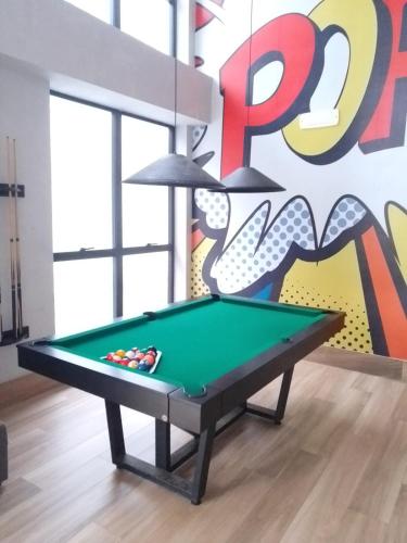 a pool table in a room with a mural at Piratininga - Niterói RJ in Niterói