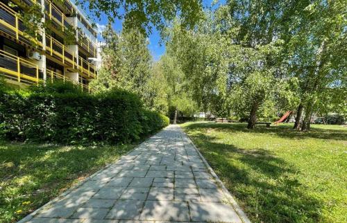 a brick path in a park next to a building at Infinity Beach Germering in Balatonfüred