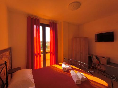a hotel room with a bed with towels on it at B&B Mamuthones in Porto Torres