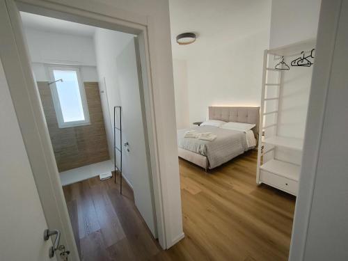 a white bedroom with a bed and a mirror at Faber Home in Conversano