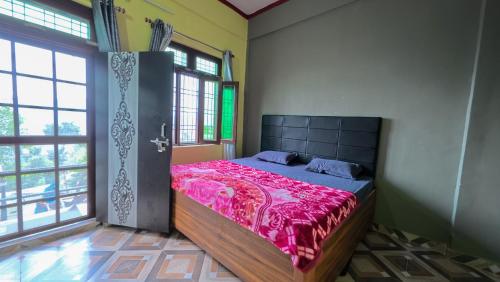 a bedroom with a large bed in a room with windows at Mahi Restaurant & Guest House in Almora