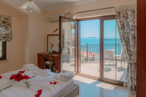 a bedroom with a bed and a balcony with the ocean at Villa Limon, Cukurbag Peninsula-Kas in Kaş