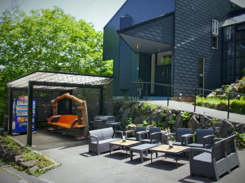 un patio con mesas y sillas y un parque infantil. en クリエイティブな人の遊び場!最大16名リンカンスタジオRINKAN Studio, en Ito