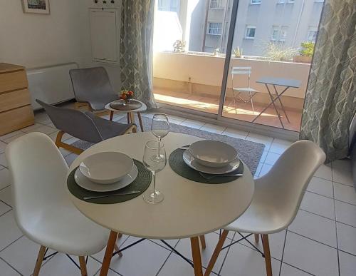 - une table et des chaises avec des verres et des assiettes dans l'établissement Studio ensoleillé centre ville tour Luma, à Arles