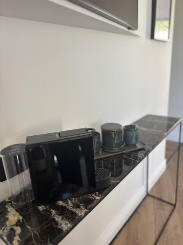 - un comptoir de cuisine avec cuisinière et casseroles dans l'établissement L'Écrin de la Sapinière, à Merville