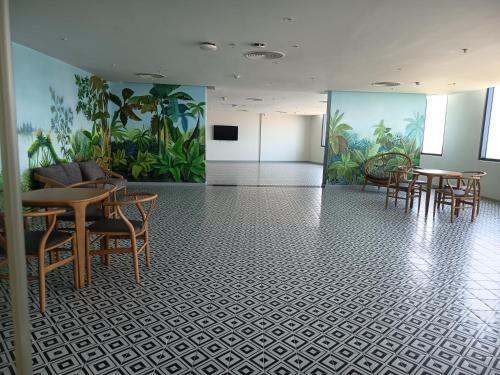 a room with tables and chairs and a mural at Sarang Arena Cam Ranh Seaview Resort condotel in Cam Ranh International Airport