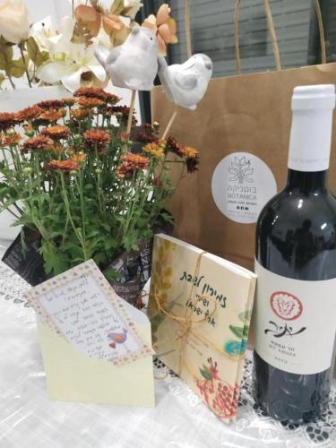 a bottle of wine sitting next to a box of flowers at avraham B''H in Nevatim