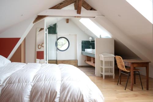 a bedroom with a white bed and a desk at Élégante longère, piscine entre Tours et Amboise in Vernou-sur-Brenne
