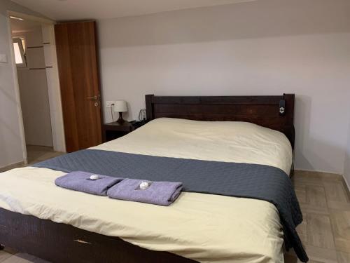 a bed with two purple towels on top of it at avraham B''H in Nevatim