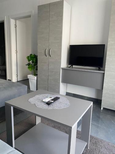 a living room with a white table and a tv at Prenoćište SILVER LUX Srebrno Jezero 10 in Veliko Gradište