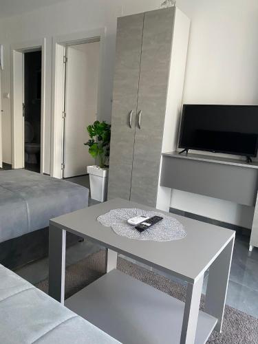 a living room with a table and a tv at Prenoćište SILVER LUX Srebrno Jezero 10 in Veliko Gradište