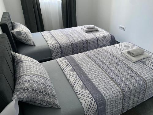two beds with gray and white comforters and pillows at Prenoćište SILVER LUX Srebrno Jezero 10 in Veliko Gradište
