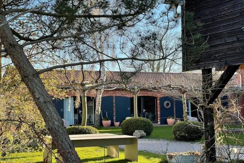 ein blaues Haus mit einer Bank davor in der Unterkunft Idyllischer Hof mit 5 Wohnungen nahe des Saaler Boddens in Saal