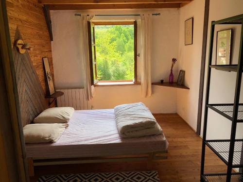 une chambre avec un lit et une fenêtre dans l'établissement Les Abeilles, à Eymoutiers