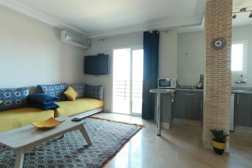 a living room with a yellow couch and a table at Dar Guéliz in Marrakech