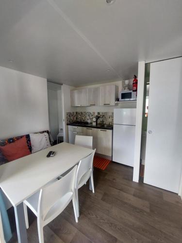 a white table and chairs in a small kitchen at Camping Al Lago Ledro in Ledro