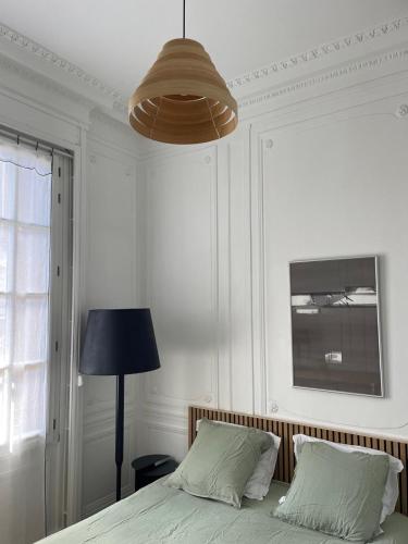 une chambre avec un lit avec une lampe et un luminaire dans l'établissement Plein centre Cathédrale Saint Leu Hortillonnages, à Amiens