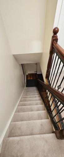 a stairway with a wooden railing and a stair case at Eastham Cottage Betaghstown in Bettystown