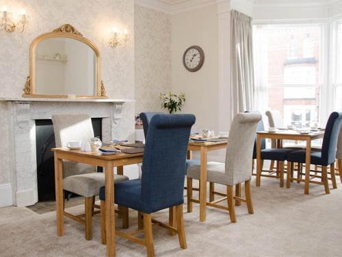 Un comedor con una mesa y sillas y un espejo. en Rosslyn House, en Whitby
