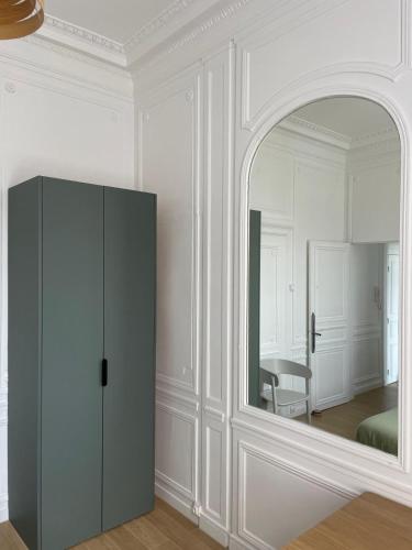 Cette chambre blanche dispose d'un miroir et d'une armoire. dans l'établissement Plein centre Cathédrale Saint Leu Hortillonnages, à Amiens