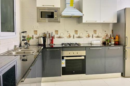 una cucina con lavello e fornello forno superiore di The fabulous appt with pool in Virage Yoff Dakar a Dakar