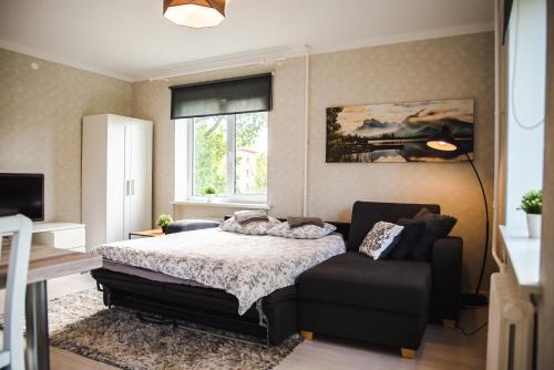 a bedroom with a bed and a chair and a window at Centrum Apartment in Valga