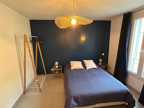 - une chambre avec un lit bleu et un mur noir dans l'établissement LAtelier T3 proche Aix et Marseille, à Gardanne