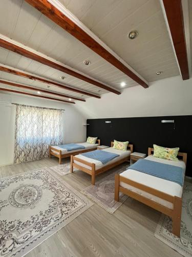 a room with two beds and a rug at Family Flower House in Sarajevo