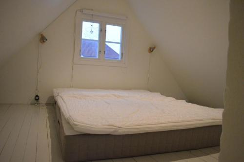a bed in a small room with a window at Litet mysigt hus i Östra Göinge in Västraby